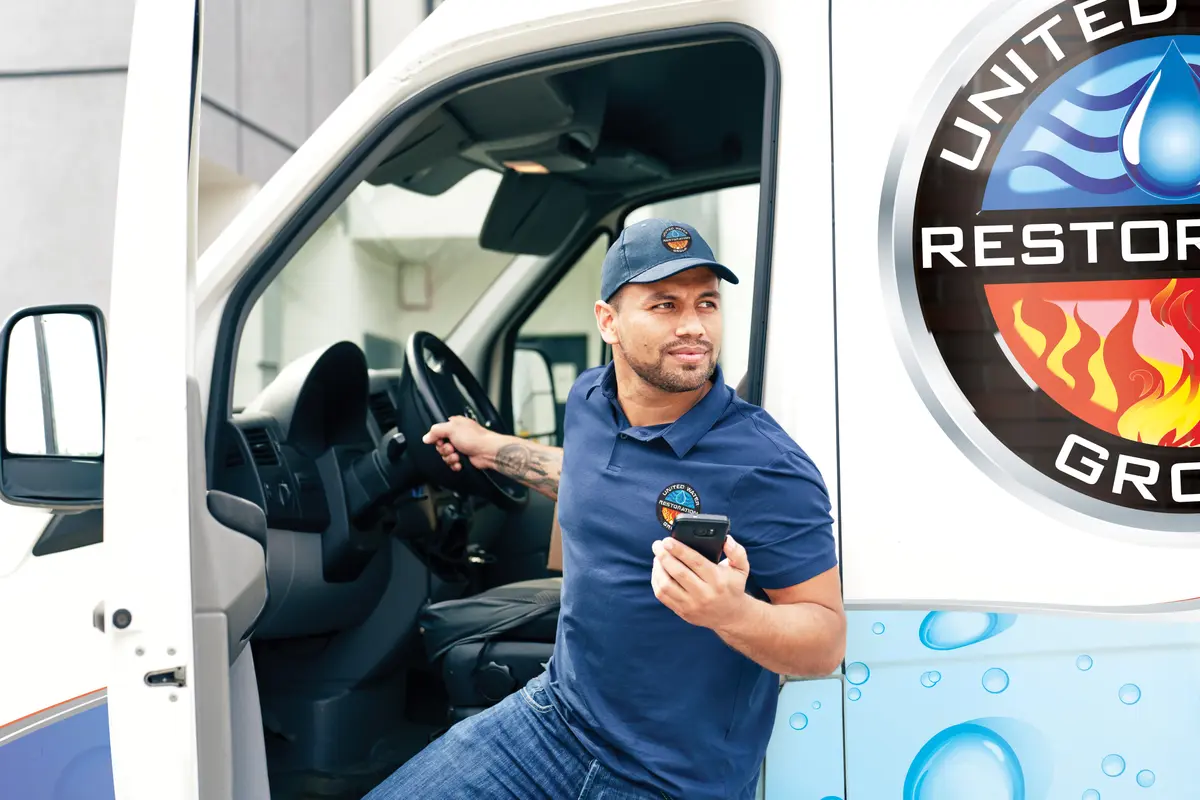 Restoration technician preparing equipment at the van